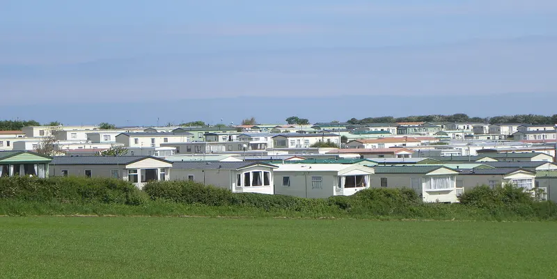 Rows and rows of static caravans beyond a grassy field